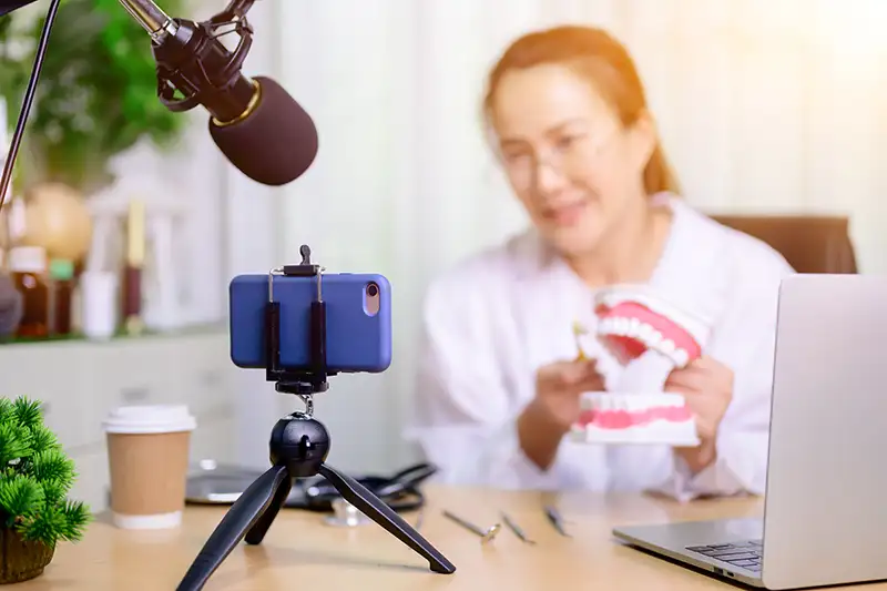 Dentist recording educational dental video with phone Dentist recording educational dental video with phone