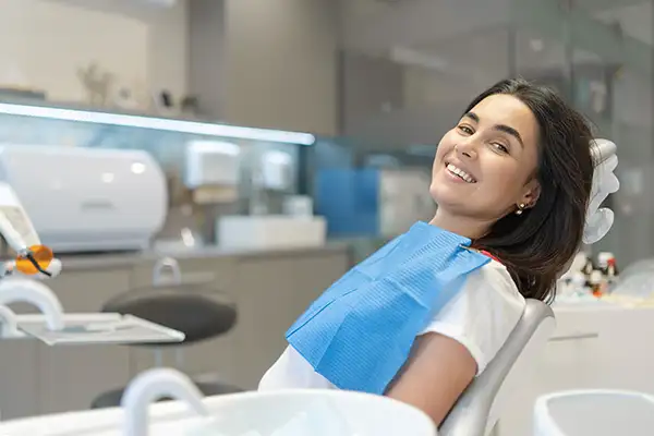 Happy patient sitting in the chair at dental clinic