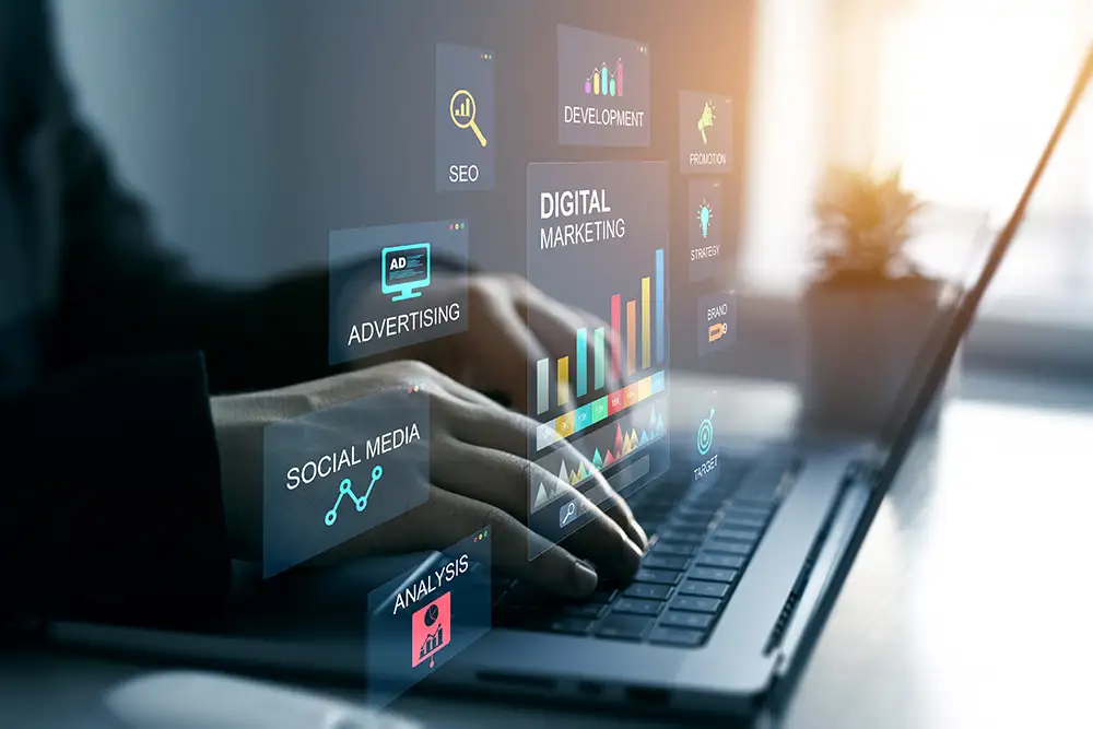 Hands typing on laptop with digital marketing screens